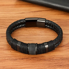 Cargar imagen en el visor de la galería, Woven leather rope stainless steel men's bracelet on a wooden surface, showcasing durable craftsmanship and sleek design.