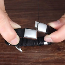 Load image into Gallery viewer, Close-up of cross vegan leather bracelet with metal clasp, ideal gift for loved ones, shown on dark wooden background.