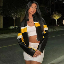 Charger l'image dans la galerie, Woman wearing a stylish black and yellow patchwork vegan leather jacket on a night out in an urban setting.