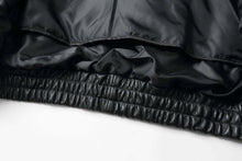 Load image into Gallery viewer, Close-up of REED Bomber Jacket's black genuine leather and inner lining detail