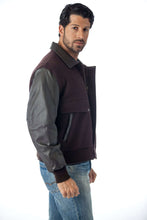 Charger l'image dans la galerie, Model wearing REED men's leather varsity bomber jacket with wool body and leather sleeves, crafted in USA, stylish mid-weight design.