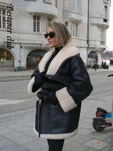 Load image into Gallery viewer, Woman wearing Cozy Chic Vegan Leather Bomber Jacket with faux wool lining, standing stylishly in an urban setting.