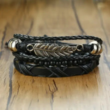 Cargar imagen en el visor de la galería, Vnox vegan leather bracelets set with feather and bead accents, showcasing ethnic charm and rugged elegance on wood surface.