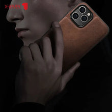 Load image into Gallery viewer, Luxury hybrid leather iPhone case showcasing premium craftsmanship and protection, held elegantly by a person in a dark setting.