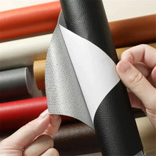 Charger l'image dans la galerie, Person demonstrating peeling patch for leather repair, showcasing rolls of colored leather in background.