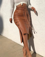 Load image into Gallery viewer, Women's high-waist faux leather midi skirt with button trim and belt, styled elegantly with a white top.