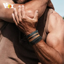Cargar imagen en el visor de la galería, Man wearing Vnox 4-piece vegan leather braided wrap bracelets, showcasing ethnic charm and rugged elegance.