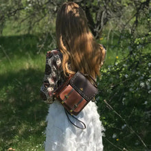 Load image into Gallery viewer, Woman wearing a stylish Bumblebee vegan leather backpack in a natural outdoor setting, perfect for professionals valuing style and function.