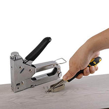 Charger l'image dans la galerie, Heavy-duty eZthings staple gun in use, shown on wooden surface with nail remover, ideal for carpentry, upholstery, decoration, and furniture.