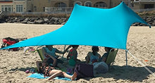 Charger l'image dans la galerie, Royal blue UV light sun shade beach shelter with sandbag anchors providing protection for people relaxing on a sunny beach.