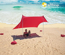 Charger l'image dans la galerie, Royal Blue eZthings UV Light Sun Shade Protection Beach Shelter on sandy beach with sandbag anchors, providing 98% UV protection.