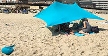 Charger l'image dans la galerie, UV light sun shade beach shelter with sandbag anchors providing protection from harmful UV rays on a sandy beach.