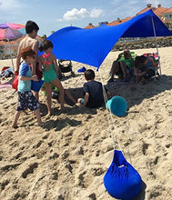 Charger l'image dans la galerie, Royal Blue UV Light Sun Shade Protection Beach Shelter with Sandbag Anchors providing sunburn protection on a sunny beach day.