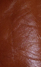 Cargar imagen en el visor de la galería, Close-up of luxurious REED sheepskin leather hide, soft and durable, showcasing a rich brown color and textured antique finish.