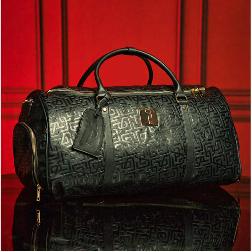 Luxurious black leather duffle bag with monogram print, ideal for travel with TSA approval. Limited edition run of 150. Dimensions 22