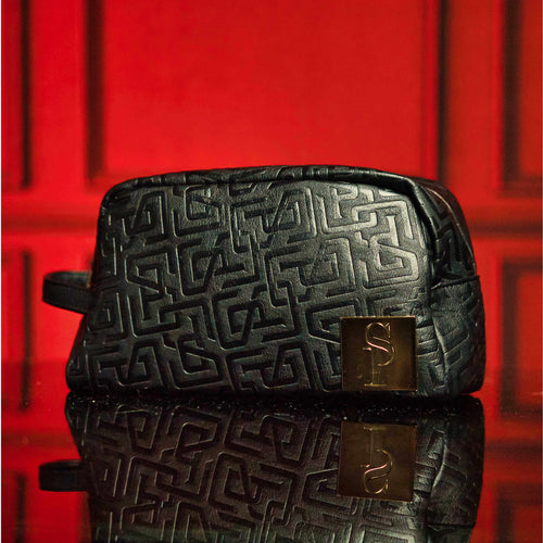Black monogram leather toiletry bag with waterproof lining and metal zipper, perfect for travel or everyday use.