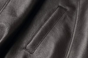 Close-up of genuine leather texture on REED Men's American Style Bomber Jacket, showcasing sleek and durable design.
