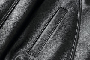 Close-up of REED Men's American Style Bomber Genuine Leather Jacket showcasing black leather texture and sleek stitching details.