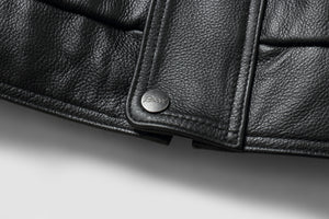 Close-up of REED Men's genuine leather bomber jacket showing detailed texture and branded button, showcasing craftsmanship.