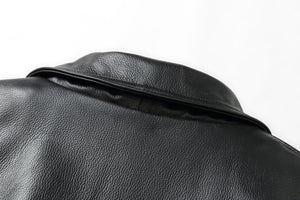 Close-up of black genuine leather on REED Men's American Style Bomber Jacket, showcasing texture and craftsmanship.