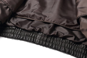 Close-up of REED Men's American Style Bomber Jacket with soft genuine leather and durable ribbed hem detail.
