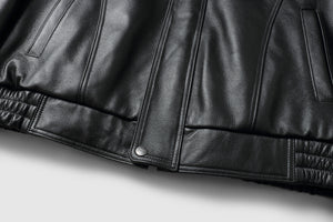 Close-up of REED Men's Bomber Genuine Leather Jacket showcasing sleek black leather texture and stylish design.