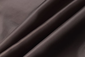Close-up of smooth, luxurious brown genuine leather fabric folds