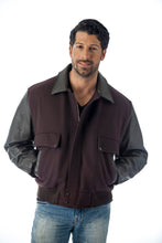 Charger l&#39;image dans la galerie, Men&#39;s leather varsity bomber jacket by REED, made in USA, featuring wool body and leather sleeves, worn by model with hands in pockets.
