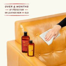 Cargar imagen en el visor de la galería, Person using Large Leather Care Kit to condition leather couch with included products and cloth for leather protection and cleaning.
