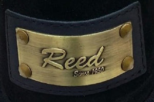 Close-up of Reed brand metal label on leather product, showcasing antique finish and craftsmanship.