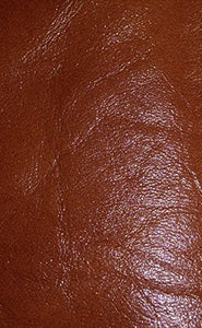 Close-up of luxurious REED sheepskin leather hide, soft and durable, showcasing a rich brown color and textured antique finish.